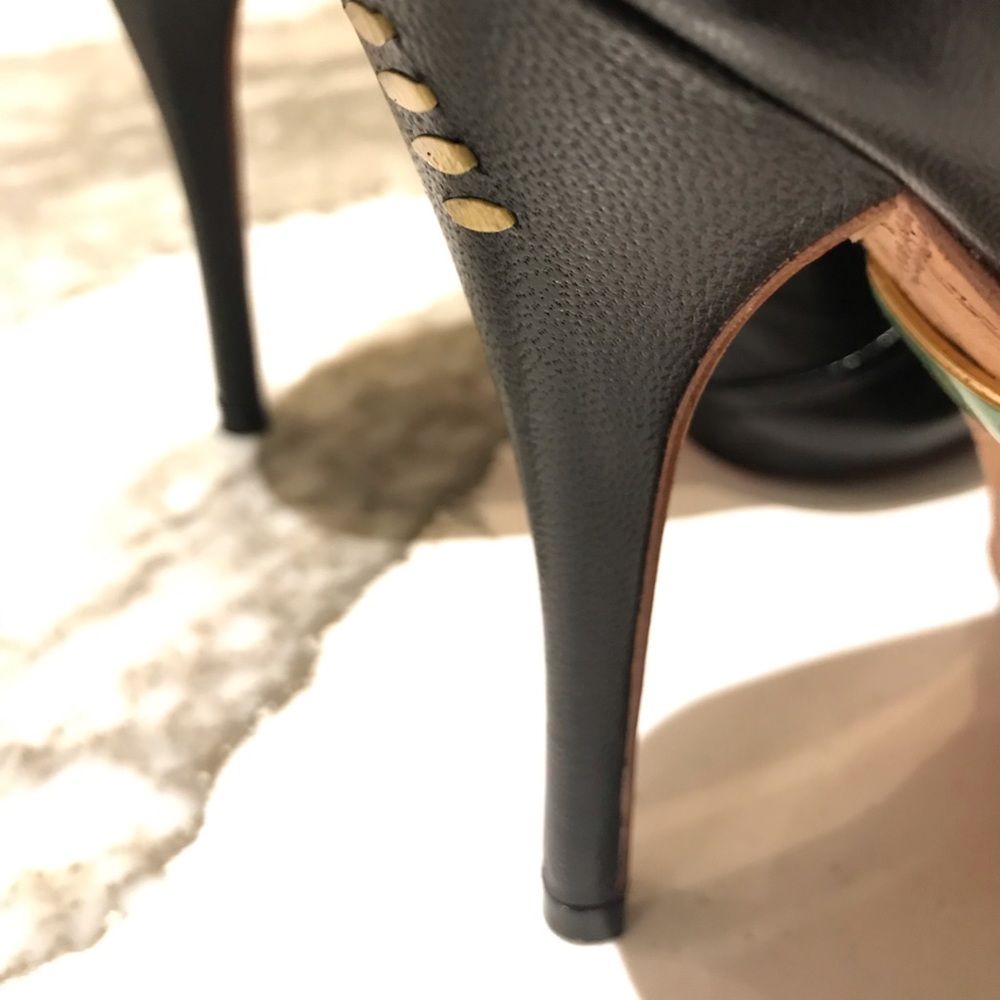 L.A.M.B black ankle boot with gold accents.